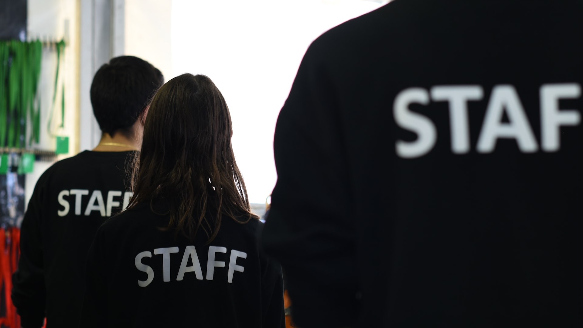 a group of people in black shirts standing in a room